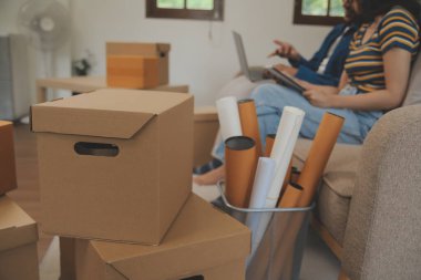 Güzel, genç ve aşık bir çift yeni dairelerine taşınırken karton kutulardan bir şeyler çıkarırken eğleniyorlar.