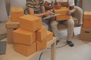 İş yerinde bilgisayarla çalışan küçük bir işletme sahibi. Serbest çalışan iki kadın satıcı ürün siparişini kontrol ediyor. Müşteriye teslimat için mal paketliyorum. Çevrimiçi satış. E-ticaret. Çevrimiçi Alışveriş