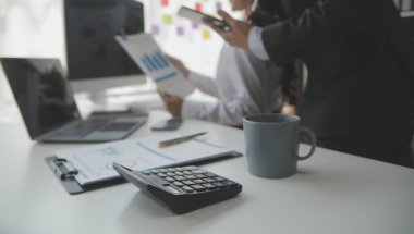 Hesap makinesi ve dizüstü bilgisayarı kullanarak ahşap masa, vergi, muhasebe, istatistik ve analitik araştırma konseptine matematik finansmanı sağlayan İş kadını kapat
