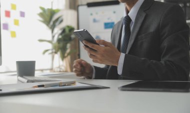 Hesap makinesi ve dizüstü bilgisayarı kullanarak ahşap masa, vergi, muhasebe, istatistik ve analitik araştırma konseptine matematik finansmanı sağlayan İş kadını kapat