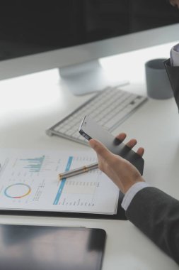 Hesap makinesi ve dizüstü bilgisayarı kullanarak ahşap masa, vergi, muhasebe, istatistik ve analitik araştırma konseptine matematik finansmanı sağlayan İş kadını kapat