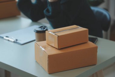 Startup SME small business entrepreneur of freelance Asian woman using a laptop with box Cheerful success Asian woman her hand lifts up online marketing packaging box and delivery SME idea concept