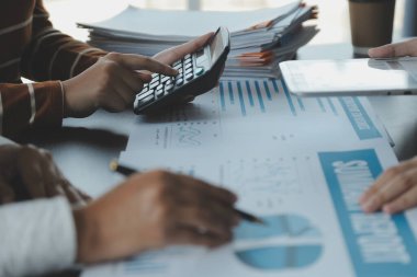 Finansal analistler, şirketlerin başarılı takım çalışmalarının sonuçlarını gösteren bir toplantıda bir dijital tablet planlama yatırım projesinin ticari mali raporlarını analiz ediyorlar..