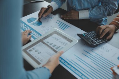 Finansal analistler, şirketlerin başarılı takım çalışmalarının sonuçlarını gösteren bir toplantıda bir dijital tablet planlama yatırım projesinin ticari mali raporlarını analiz ediyorlar..
