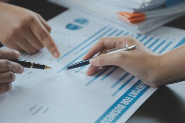 Finansal analistler, şirketlerin başarılı takım çalışmalarının sonuçlarını gösteren bir toplantıda bir dijital tablet planlama yatırım projesinin ticari mali raporlarını analiz ediyorlar..