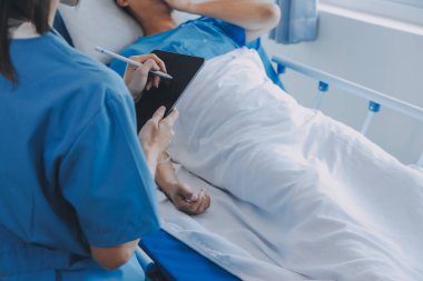 Asyalı kadın doktorlar hastanın elini tutarlar ve hasta sağlığını kontrol ederken ona tıbbi tavsiyelerde bulunurlar. Bakım ve şefkat kavramı, doğum öncesi bakım, kürtaj tehdidi