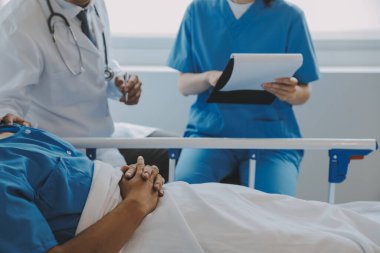 Asyalı kadın doktorlar hastanın elini tutarlar ve hasta sağlığını kontrol ederken ona tıbbi tavsiyelerde bulunurlar. Bakım ve şefkat kavramı, doğum öncesi bakım, kürtaj tehdidi