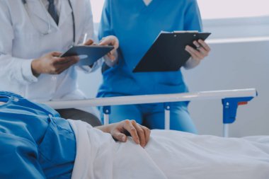 Asyalı kadın doktorlar hastanın elini tutarlar ve hasta sağlığını kontrol ederken ona tıbbi tavsiyelerde bulunurlar. Bakım ve şefkat kavramı, doğum öncesi bakım, kürtaj tehdidi