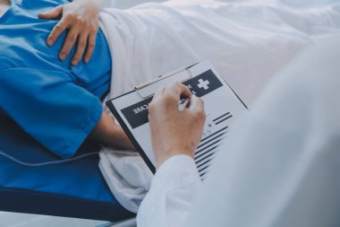 Asyalı kadın doktorlar hastanın elini tutarlar ve hasta sağlığını kontrol ederken ona tıbbi tavsiyelerde bulunurlar. Bakım ve şefkat kavramı, doğum öncesi bakım, kürtaj tehdidi