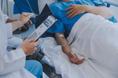 Asyalı kadın doktorlar hastanın elini tutarlar ve hasta sağlığını kontrol ederken ona tıbbi tavsiyelerde bulunurlar. Bakım ve şefkat kavramı, doğum öncesi bakım, kürtaj tehdidi