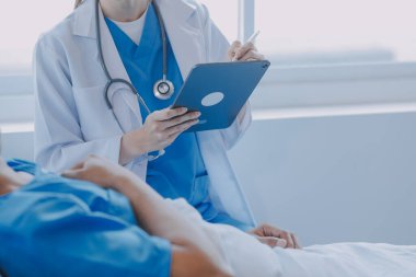 Asyalı kadın doktorlar hastanın elini tutarlar ve hasta sağlığını kontrol ederken ona tıbbi tavsiyelerde bulunurlar. Bakım ve şefkat kavramı, doğum öncesi bakım, kürtaj tehdidi