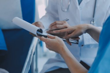 Asyalı kadın doktorlar hastanın elini tutarlar ve hasta sağlığını kontrol ederken ona tıbbi tavsiyelerde bulunurlar. Bakım ve şefkat kavramı, doğum öncesi bakım, kürtaj tehdidi