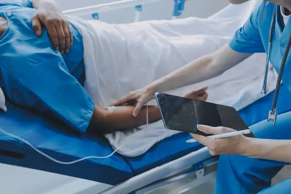 stock image Women Asian doctors hold the patient hand and encourage and provide medical advice While checking the patient health in bed. Concept of Care and compassion, antenatal care, Threatened abortion