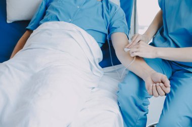 Asyalı kadın doktorlar hastanın elini tutarlar ve hasta sağlığını kontrol ederken ona tıbbi tavsiyelerde bulunurlar. Bakım ve şefkat kavramı, doğum öncesi bakım, kürtaj tehdidi