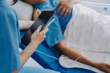 Asyalı kadın doktorlar hastanın elini tutarlar ve hasta sağlığını kontrol ederken ona tıbbi tavsiyelerde bulunurlar. Bakım ve şefkat kavramı, doğum öncesi bakım, kürtaj tehdidi