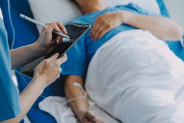 Asyalı kadın doktorlar hastanın elini tutarlar ve hasta sağlığını kontrol ederken ona tıbbi tavsiyelerde bulunurlar. Bakım ve şefkat kavramı, doğum öncesi bakım, kürtaj tehdidi