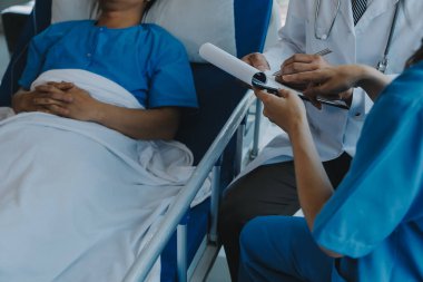 Asyalı kadın doktorlar hastanın elini tutarlar ve hasta sağlığını kontrol ederken ona tıbbi tavsiyelerde bulunurlar. Bakım ve şefkat kavramı, doğum öncesi bakım, kürtaj tehdidi