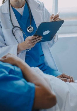 Asyalı kadın doktorlar hastanın elini tutarlar ve hasta sağlığını kontrol ederken ona tıbbi tavsiyelerde bulunurlar. Bakım ve şefkat kavramı, doğum öncesi bakım, kürtaj tehdidi