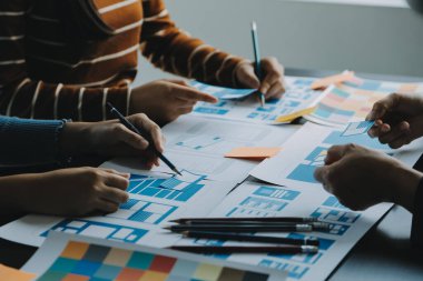 Mobil uygulama arayüzü kablo dizaynı hakkında modern ofisteki müşteri breif ve renk kodu ile fikir alışverişinde bulunan uu geliştirici ve ui tasarımcısını kapat. Yaratıcı dijital geliştirme ajansı