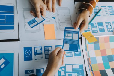 Mobil uygulama arayüzü kablo dizaynı hakkında modern ofisteki müşteri breif ve renk kodu ile fikir alışverişinde bulunan uu geliştirici ve ui tasarımcısını kapat. Yaratıcı dijital geliştirme ajansı