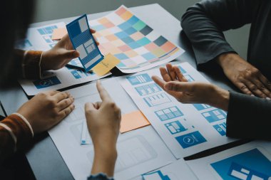 Mobil uygulama arayüzü kablo dizaynı hakkında modern ofisteki müşteri breif ve renk kodu ile fikir alışverişinde bulunan uu geliştirici ve ui tasarımcısını kapat. Yaratıcı dijital geliştirme ajansı