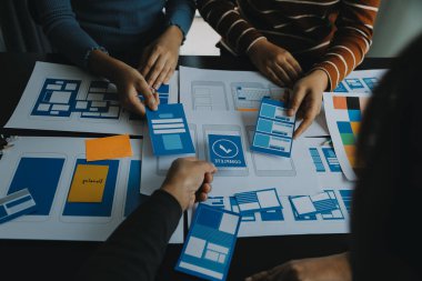 Mobil uygulama arayüzü kablo dizaynı hakkında modern ofisteki müşteri breif ve renk kodu ile fikir alışverişinde bulunan uu geliştirici ve ui tasarımcısını kapat. Yaratıcı dijital geliştirme ajansı