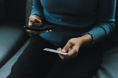 Dışarıda oturup dizüstü bilgisayar kullanan güzel bir kadın. Kadın ve arkadaşı yeni teknolojiyle eğleniyor ve açık havada online alışveriş yapıyorlar..