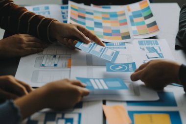 Mobil uygulama arayüzü kablo dizaynı hakkında modern ofisteki müşteri breif ve renk kodu ile fikir alışverişinde bulunan uu geliştirici ve ui tasarımcısını kapat. Yaratıcı dijital geliştirme ajansı