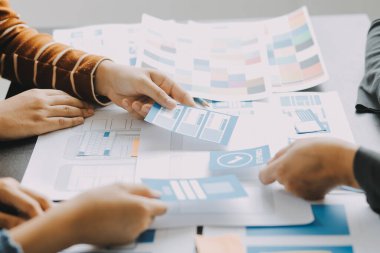 Mobil uygulama arayüzü kablo dizaynı hakkında modern ofisteki müşteri breif ve renk kodu ile fikir alışverişinde bulunan uu geliştirici ve ui tasarımcısını kapat. Yaratıcı dijital geliştirme ajansı