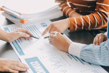 Finansal analistler, şirketlerin başarılı takım çalışmalarının sonuçlarını gösteren bir toplantıda bir dijital tablet planlama yatırım projesinin ticari mali raporlarını analiz ediyorlar..