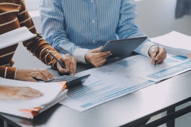 Finansal analistler, şirketlerin başarılı takım çalışmalarının sonuçlarını gösteren bir toplantıda bir dijital tablet planlama yatırım projesinin ticari mali raporlarını analiz ediyorlar..