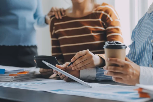 Stock image Financial analysts analyze business financial reports on a digital tablet planning investment project during a discussion at a meeting of corporate showing the results of their successful teamwork.