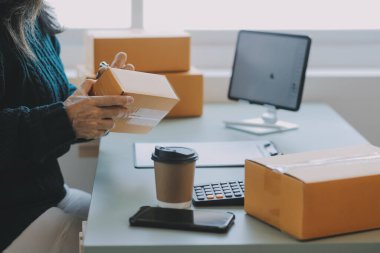 Girişimciler Küçük İşletme Bağımsız Adamlar evde çalışıyor. Ticari denetim, çevrimiçi pazarlama, paketleme, KOBİ satıcıları, konsept, e-ticaret ekibi, çevrimiçi satış için akıllı telefon ve dizüstü bilgisayar kullanın.