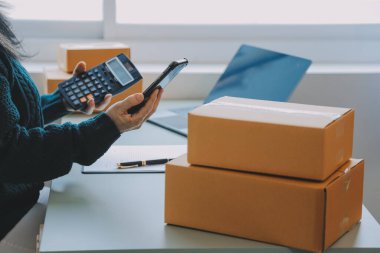 Girişimciler Küçük İşletme Bağımsız Adamlar evde çalışıyor. Ticari denetim, çevrimiçi pazarlama, paketleme, KOBİ satıcıları, konsept, e-ticaret ekibi, çevrimiçi satış için akıllı telefon ve dizüstü bilgisayar kullanın.
