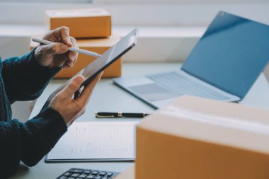 Girişimciler Küçük İşletme Bağımsız Adamlar evde çalışıyor. Ticari denetim, çevrimiçi pazarlama, paketleme, KOBİ satıcıları, konsept, e-ticaret ekibi, çevrimiçi satış için akıllı telefon ve dizüstü bilgisayar kullanın.