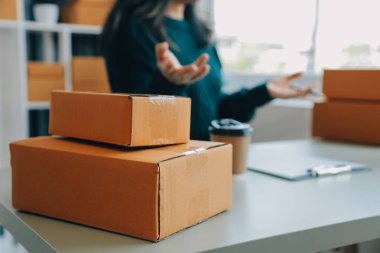 Girişim KOBİ küçük işletme girişimcisi önlük giyen Asyalı kadın dizüstü bilgisayar ve kutu kullanarak çevrimiçi müşterilere, çevrimiçi sme iş fikirlerine satış hazırlamak için siparişleri alır ve gözden geçirir.