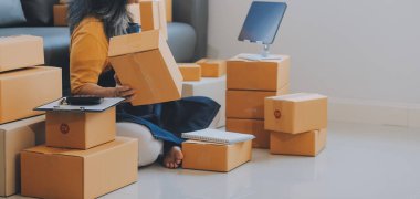 Startup SME small business entrepreneur of freelance Asian woman using a laptop with box Cheerful success Asian woman her hand lifts up online marketing packaging box and delivery SME idea concept