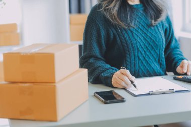 Startup SME small business entrepreneur of freelance Asian woman using a laptop with box Cheerful success Asian woman her hand lifts up online marketing packaging box and delivery SME idea concept