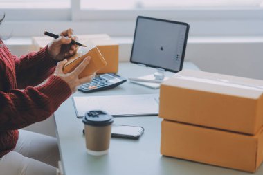Startup SME small business entrepreneur of freelance Asian woman using a laptop with box Cheerful success Asian woman her hand lifts up online marketing packaging box and delivery SME idea concept