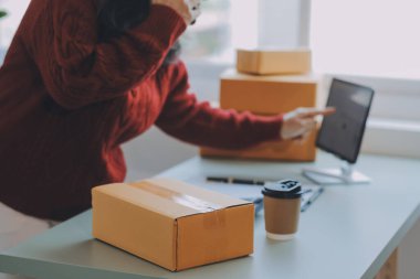 Startup SME small business entrepreneur of freelance Asian woman using a laptop with box Cheerful success Asian woman her hand lifts up online marketing packaging box and delivery SME idea concept
