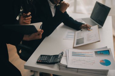 Finansal analistler, şirketlerin başarılı takım çalışmalarının sonuçlarını gösteren bir toplantıda bir dijital tablet planlama yatırım projesinin ticari mali raporlarını analiz ediyorlar..