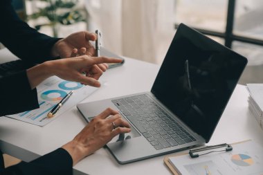 Finansal analistler, şirketlerin başarılı takım çalışmalarının sonuçlarını gösteren bir toplantıda bir dijital tablet planlama yatırım projesinin ticari mali raporlarını analiz ediyorlar..