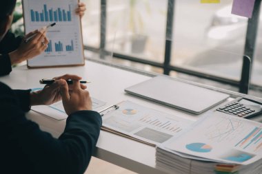 Finansal analistler, şirketlerin başarılı takım çalışmalarının sonuçlarını gösteren bir toplantıda bir dijital tablet planlama yatırım projesinin ticari mali raporlarını analiz ediyorlar..