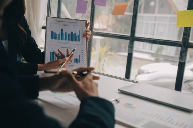 Finansal analistler, şirketlerin başarılı takım çalışmalarının sonuçlarını gösteren bir toplantıda bir dijital tablet planlama yatırım projesinin ticari mali raporlarını analiz ediyorlar..