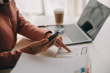Çekici gülümseyen Asyalı iş kadını ev ofisinde çalışıyor, Asyalı kadın dizüstü bilgisayarında tablet tutuyor..
