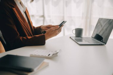 Çekici gülümseyen Asyalı iş kadını ev ofisinde çalışıyor, Asyalı kadın dizüstü bilgisayarında tablet tutuyor..