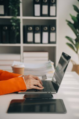 Hesap makinesi ve dizüstü bilgisayarı kullanarak ahşap masa, vergi, muhasebe, istatistik ve analitik araştırma konseptine matematik finansmanı sağlayan İş kadını kapat