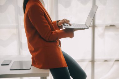 Hesap makinesi ve dizüstü bilgisayarı kullanarak ahşap masa, vergi, muhasebe, istatistik ve analitik araştırma konseptine matematik finansmanı sağlayan İş kadını kapat