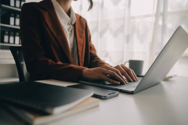 Hesap makinesi ve dizüstü bilgisayarı kullanarak ahşap masa, vergi, muhasebe, istatistik ve analitik araştırma konseptine matematik finansmanı sağlayan İş kadını kapat