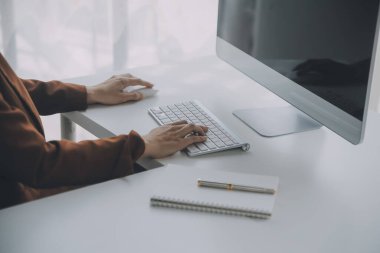 Genç Asyalı kadın portresi modern ofiste bilgisayar tableti üzerinde çalışıyor. Muhasebe analizi yapmak gayrimenkul yatırım verileri, mali ve vergi sistemleri kavramı.